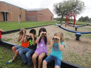 Kindergarten students are learning about the differences in birds and fish.  Students made binoculars out of tissue rolls and went bird watching.  Shown here using their binoculars are Mason Miller-Hewes, Mato Sanchez, Adamariz Zuniga, and Shelby Wheat. POC School 
