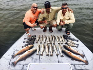 Captain Ben Boudreaux of Bay Flats Lodge with happy anglers in San Antonio Bay.
