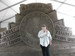 Gloria Fric with the Warrior’s Weekend sand sculpture -Photo by Joy Fryou