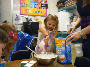 The Pre-Kindergarten class in Seadrift has started using the Big Words Club program via the computer to teach new vocabulary words. Our word for the day was fossil, so the students used plaster and shells to create a fossil. In this picture Audrey Scroggins is mixing the plaster.