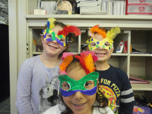 Students in Ms. Peters room show off the Mardi Gras masks they made when learning about different cultures and holidays. Enola Walton Kailey Guzman, and Bradley Eure 