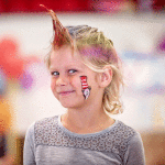 Kindergarten student Audrey Rhoads shows off her spray painted hair and face paint.