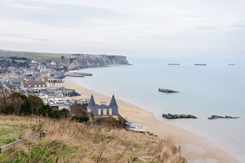 The Village of Arromanches showing remaining sunken concrete barges from the World War II Mulberry Harbor