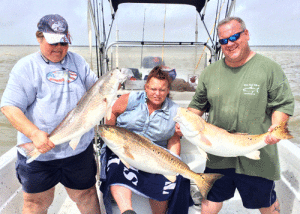 Lillian, Barby, and Jacob with the results of a triple header on Bull Redfish that were caught while fishing with Capt. RJ Shelly on May 25th. They managed to land all three fish while drifting the Jetties even though they crossed lines several times during the fight.