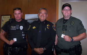 Seadrift Police Chief Leonard Bermea presents Life Saving pins to officers Robert Montero (left) and Louis Warren (right).