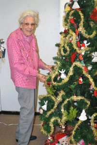 Grace Stone attaching ornaments to the Port O’Connor Library Christmas tree.