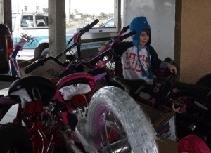 Little Helper with the Toy Run Bicycles -Photo by Kelly Gee