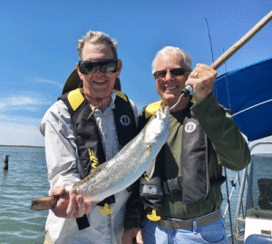 Harold Cooper caught this 26” trout during the first week in April. His very first trout. Harold was visiting from his hometown in Ashland, Kentucky and went fishing in salt water for the very first time. This trout gets even bigger with each retelling of the experience!!! An experience which he will never forget. Pictured are Harold Cooper (left) and Dave Pope, Harold’s brother-in-law.