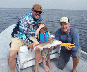 Ella with her 1st Redfish, with Dad and Capt. Jeff Larson. Mom gets the photo credit. Great times and Great Memories!!!
