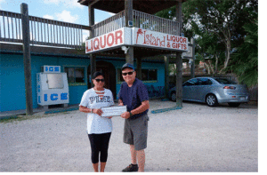 Bill Tigrett of Port O’Connor Chamber of Commerce accepts a generous donation for the Fireworks Show from Judy of Island Liquor and Gifts. 