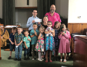 Children from Sunday’s morning service at First Baptist Church of Port O’Connor present Mr. Reed Hewitt, Director at South Texas Children’s Home, with a check for $412.16 that was collected during Vacation Bible School. -Photo by Candice Stryker