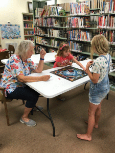 Mary Ann Claiborne, Clara Stryker and Caroline Sudderth play Monopoly during the Friends of the Library Board Game Event on June 16, 2018. -Photo by U. Price