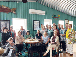 March’s “Hooked On Books” Book Club Meeting was held in the Pool House of Hostess, Ursula Price, who, along with Co-Hostesses Cindy Boone, Nita Abney, & Shaney Bradford, treated the 17 attendees to a fun and sentimental trip back to the Depression Era, in accordance with March’s Book, “This Tender Land” by William Kent Kruger.  In addition to an interesting & boisterous discussion of the book, the group sang period songs led by Charlotte Fitzgerald & viewed video clips about the book & its history. The group was also treated to Depression-era food & beverages including:  soup made from water & catsup; baked potatoes; salad; chocolate cake made without eggs, sugar, or milk; spice cake; coffee; water; & lemonade. Thank you to the Hostesses for a fabulous time- it was a great meeting!! For information on joining our fun and lively group, please contact alanehaardt@yahoo.com.  All are welcome!! 