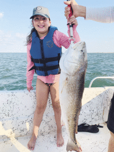 Payton Junek, granddaughter of Cal and Irene Junek, caught her first bull red at jetties  