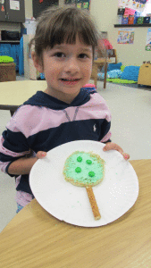 While learning about the seasons of trees, Ms. Peters Kindergarten class made an apple tree in the fall and enjoyed eating it. Pictured is Josie Clark.