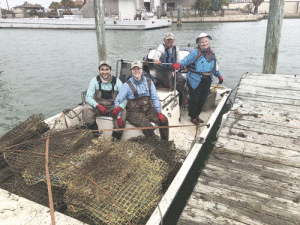 Allan Berger, Leslie Taylor, Ashley Berger, Alejandro Velasquez with crab traps to offload at TPWD dock.