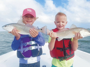 Ellie Vesely’s, age 7,   First Redfish Catch   24” red-fish caught in Port O’Connor with her cousin Scott Lesak,  7 and his dad, Kyle Lesak.   They were fishing during spring break on her visit from San Antonio in March 2021.  They also caught the smaller reds and had a fun day on the bay!   Winds and all!      	Ellie is the daughter of Hayden and Tara Vesely, San Antonio; granddaughter of Larry  and Sheila Vesely, Victoria. Scott, is the son of Kyle and Alicia Lesak,  Victoria;  grandson of Steve and Rhonda Volkmer, Victoria and Daryl and Debbie Lesak, Victoria.   