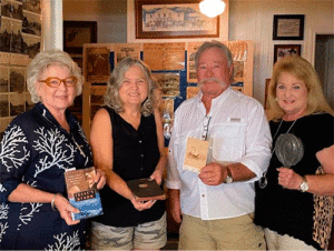 Diane Cooley, Cindy Boone, and Otto & Alane Haardt view artifacts from the Book Club’s mock “Great 1900 Storm Museum”.