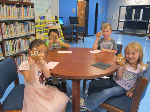 Alessia Smith, Osvin Martinez, Brodie Tubbs, and Avery Williamson finally track down the Gingerbread Man in the library.  POC Kindergarten on the first day of school went on a scavenger hunt around campus to find him. -Photo by Monica Peters