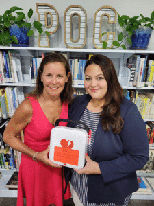 The Port O’Connor Library Branch would like to thank Susan Wallace of POC Swim for her generous donation of an AED machine to the Port O’Connor Library Branch. Susan is donating this much needed item in honor of Marie Hawes’ service to the community as a medical provider. Pictured: Susan Wallace with Librarian Michelle Marlin