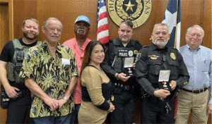 L to R: Police Lieutenant Louis Warren, Councilman Kenneth Reese, Police Commissioner Ranier Brigham, Patrol Officer Marie Carisalez, Sergeant Mike Henry, Police Chief Leonard Bermea, and Mayor Elmer DeForest 