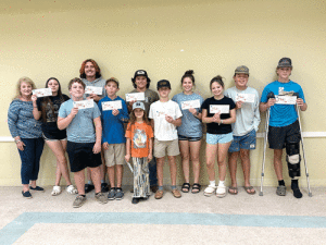 The Port O’Connor Community Service Club honored 14 members of the Intercoastal 4H Club at their November meeting for their hard work and dedication to their County Fair projects. Pictured with the 4Hers is Club member Alane Haardt.