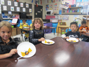 Discussing the body parts of bats, Ms. Peters’ Kindergarten class enjoyed an eatable bat.  Left to right-Everly Pompa, AJ Guzman, and Alex Guiterrez.				    -Monica Peters