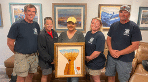 Port O’Connor Fire Department Volunteers with Xandra Mapp’s art donation. Artists Liz Hewitt and Sam Caldwell also provided works of art for the fund.