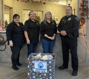 First National Bank (Seadrift Branch) tellers helping Blue Santa Toy Drive with officer James Easley.