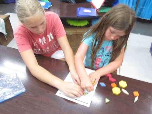 Addison Mapp (left) assists Adalynn McCabe (right) with composing and decomposing shapes. Addison is a 4th grader and Adalynn is a Kindergarten student at Port O'Connor School